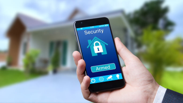 person-checking-home-security-on-phone
