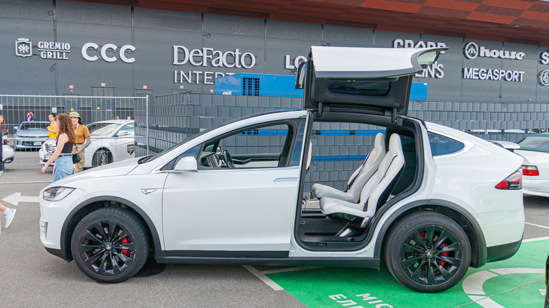2025 Tesla Model X on a public road showing its falcon wing door design.