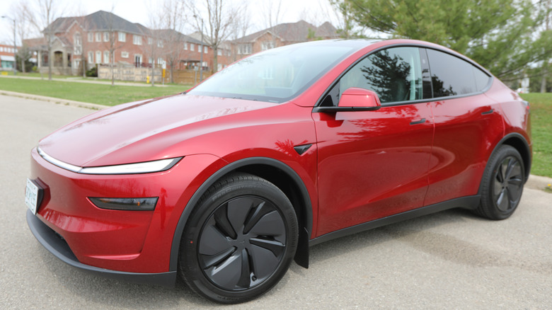2025 Tesla Model Y in red color parked in a street.