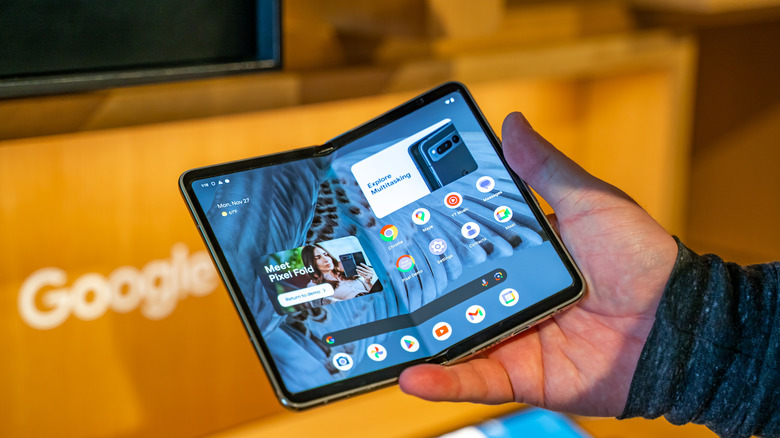 A person holding the Pixel Fold in a Google store