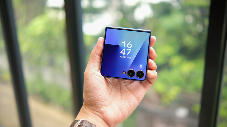 Holding a clamshell folding phone outside