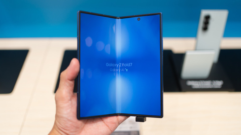 A person holding the Samsung Galaxy Fold7 in a store