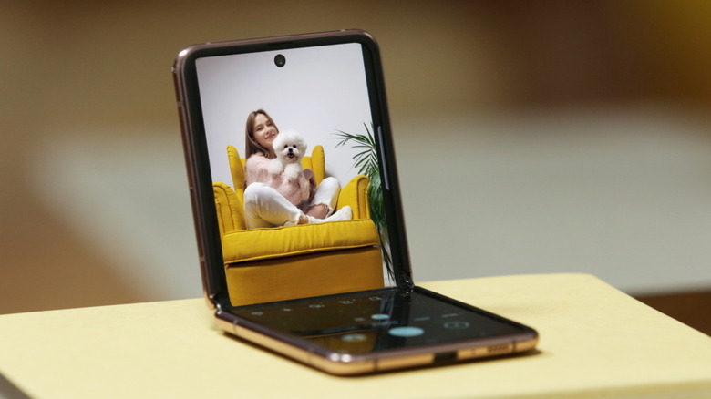 Using a half-open clamshell folding phone as a makeshift selfie stand to click a picture