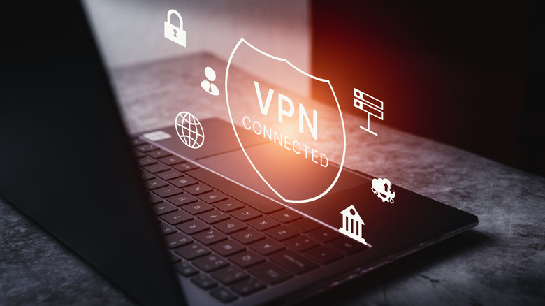 A glowing graphic of the word "VPN" hovering over a black laptop.