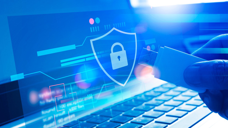 A graphic of a lock inside a shield floating in front of a laptop screen to denote cybersecurity.