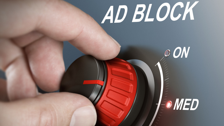A hand turning a red dial representing different levels of ad blocking.
