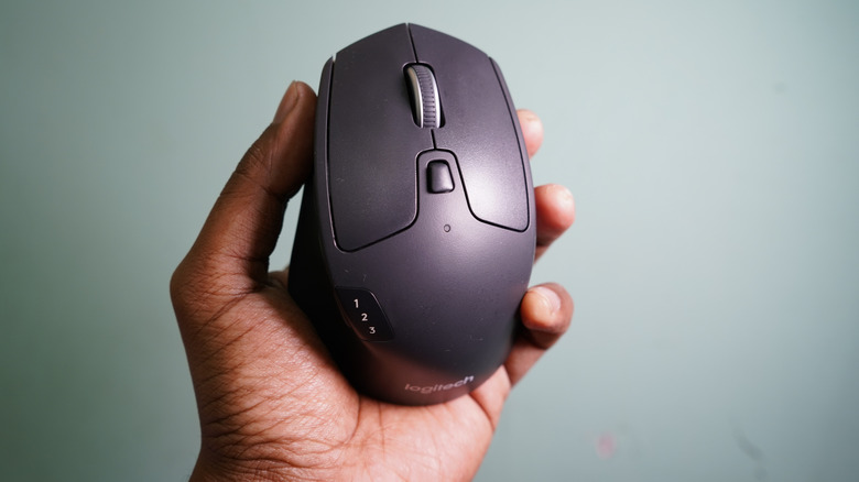 Person holding logitech wireless mouse in hand