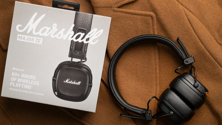 A pair of Marshall over-ear headphones next to packaging box