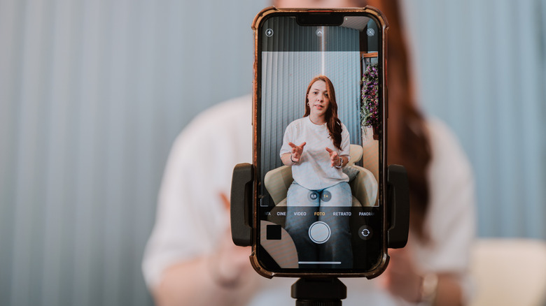 A phone on a tripod, pointed at a person