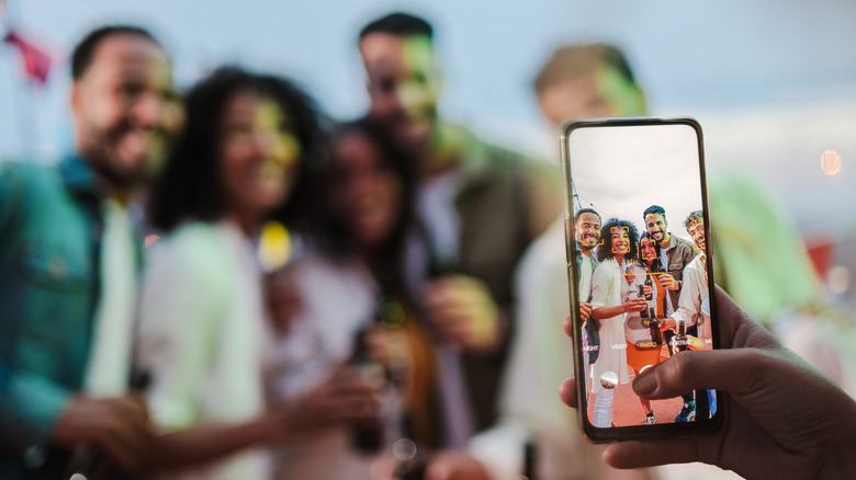 Three people taking a selfie with a smartphone