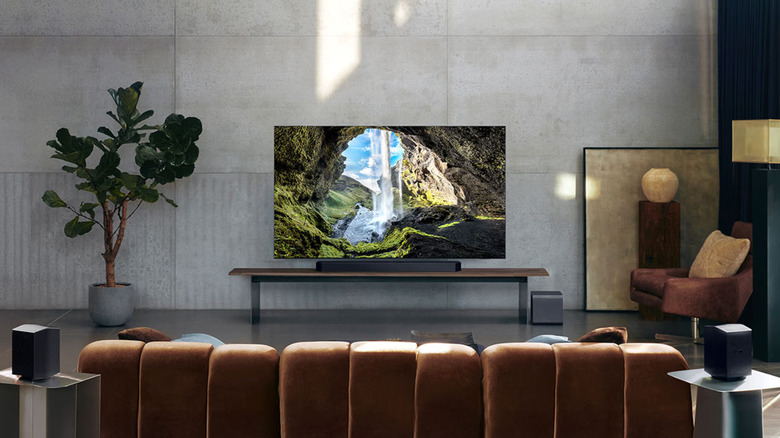 The Samsung HW-Q990F soundbar, subwoofer, and rear speakers visible in a living room setup.