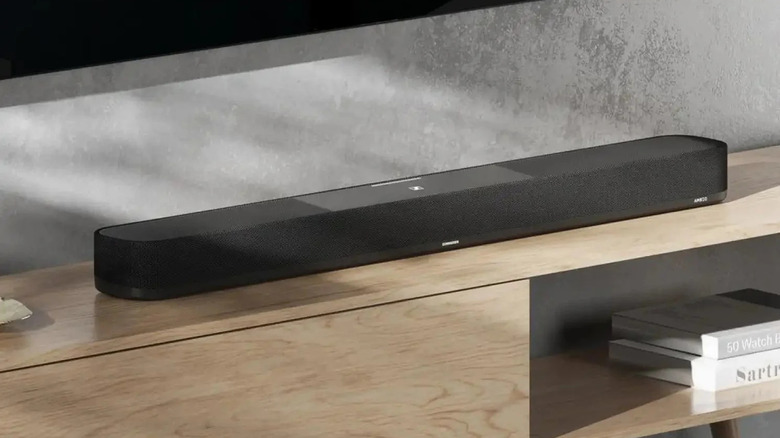 The Sennheiser Ambeo Soundbar Plus on a TV unit in a home.