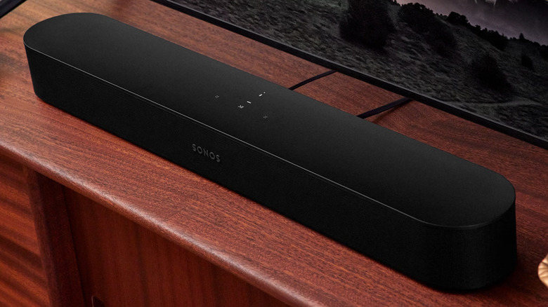 The second-generation Sonos Beam soundbar on a reddish-brown TV unit.