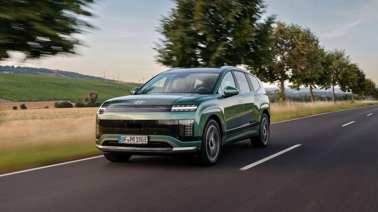 A green Hyundai Ioniq 9 speeding down a road in the countryside