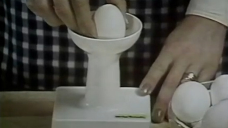 A frame from the Inside-the-Shell Egg Scrambler TV commercial showing the device in operation.