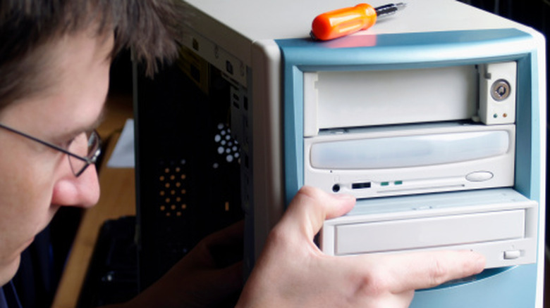 Man removing CD ROM from an old computer