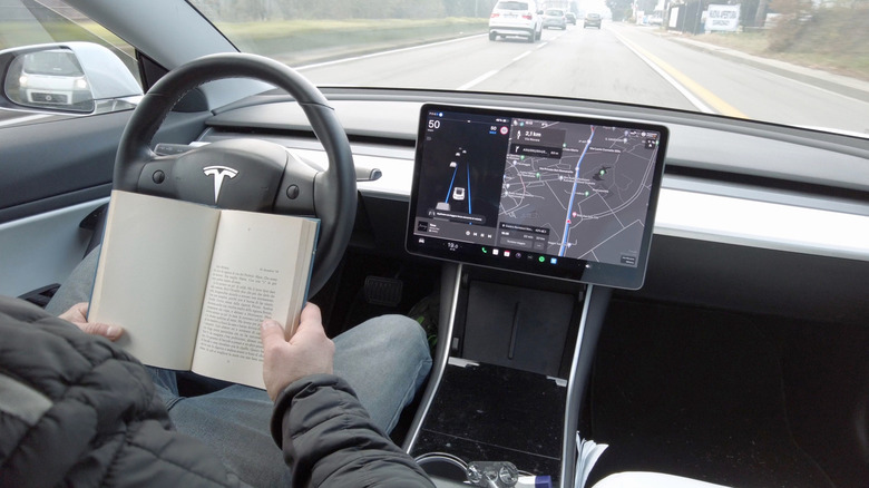 Person reading a book in a self-driving car