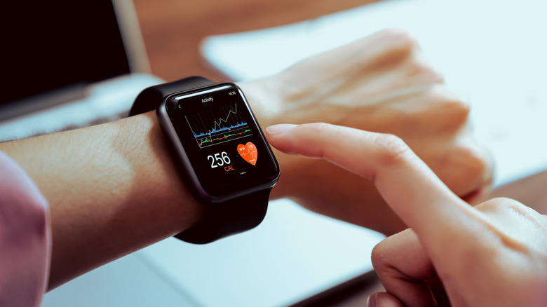 Person wearing smartwatch that shows fitness stats