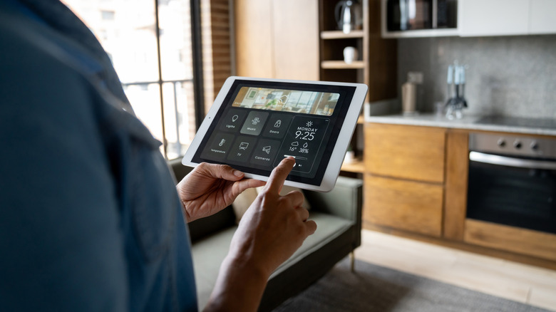 A person controlling multiple smart appliances in her living room with her phone