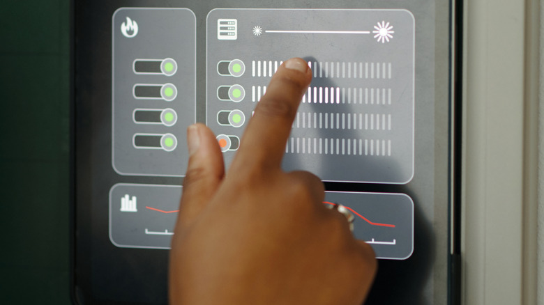 Hand manipulating a touch-screen HVAC interface