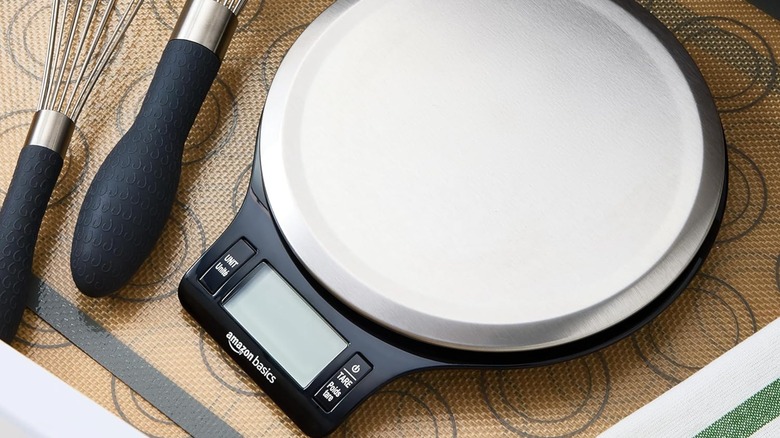 Amazon Basics digital kitchen scale on kitchen countertop next to egg whisks