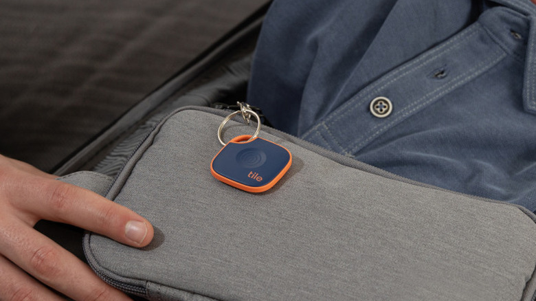 Tile Mate tracker attached to a small gray bag