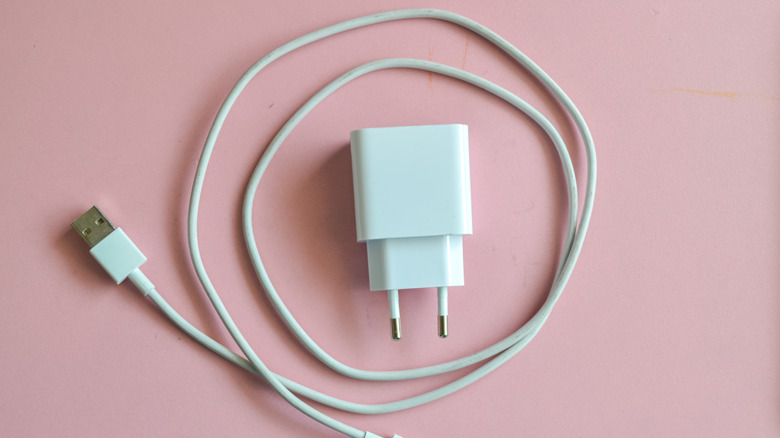 A phone charger on a pink background