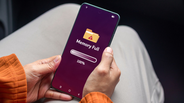 A person holding a phone that shows a message saying the memory is full