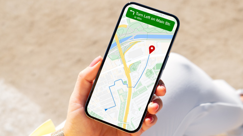 A person holding a phone navigating to a location on Google maps