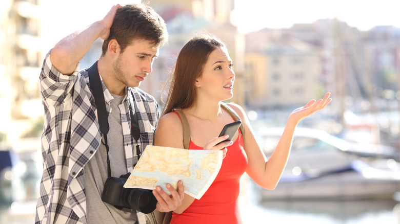 A man and a woman with a map and phone