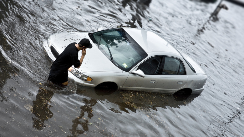 A man stuck with his car in a flash flood