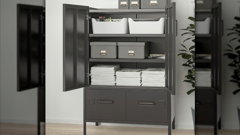Gray cabinet loaded with papers, boxes, and trays.