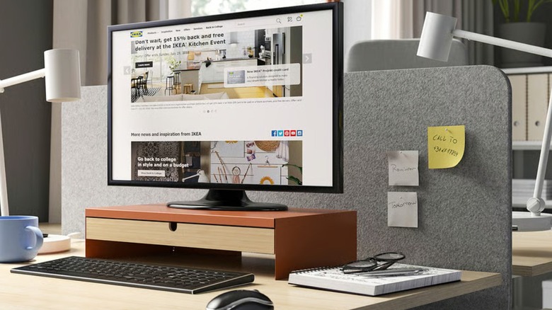A home office desk with a PC setup and work lamp.
