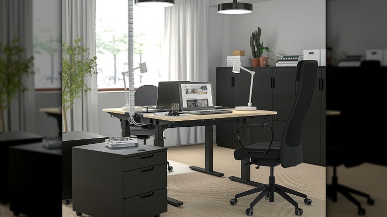 Black office chair placed in a home office with a desk.
