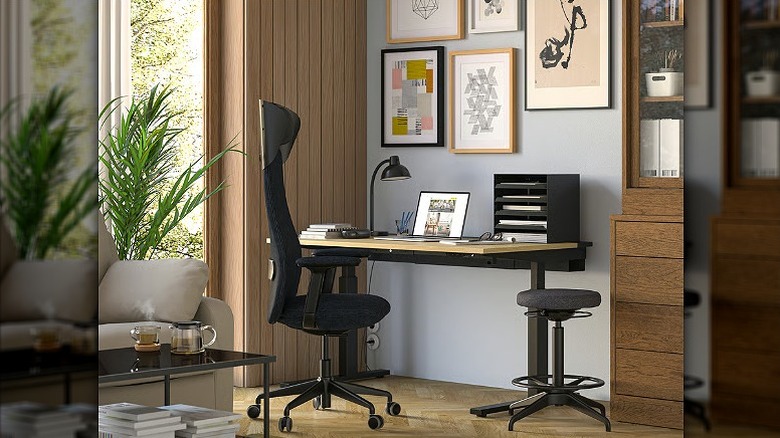 Black office chair placed against a work desk.