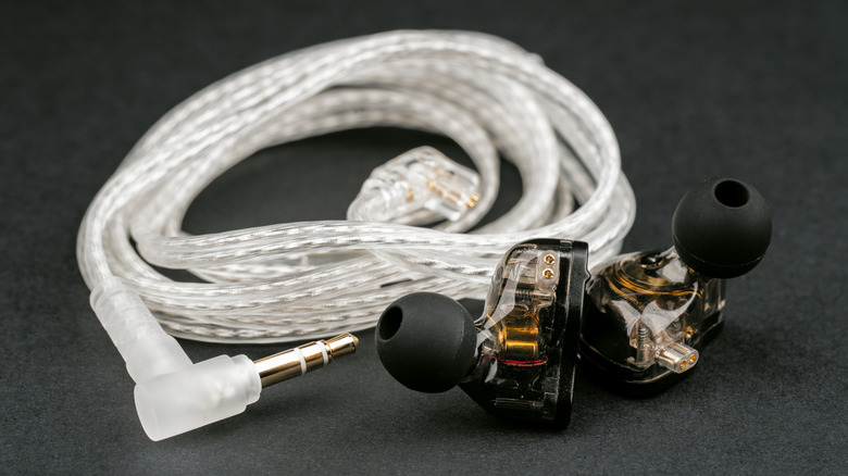 A set of in-ear monitors with its wire coiled up.