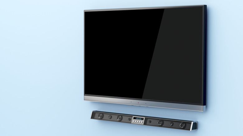 A soundbar wall-mounted under a TV