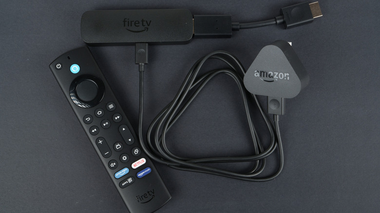 A Fire TV Stick connected to the adapter and charging cable plugged in