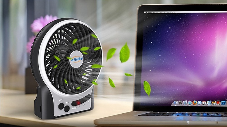 Desk fan cooling a laptop