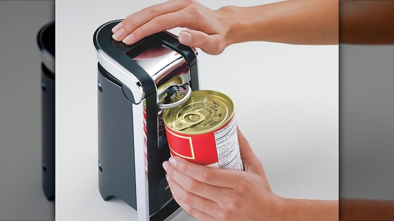 Opening a tin can lid with the can opener