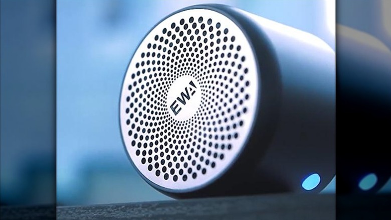 Steel cover of a Bluetooth speaker with EWA logo in the center.
