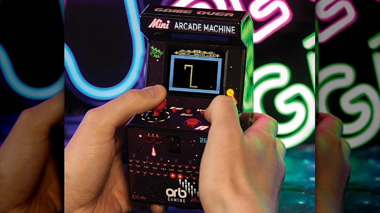 Playing a snake game on a mini arcade machine.