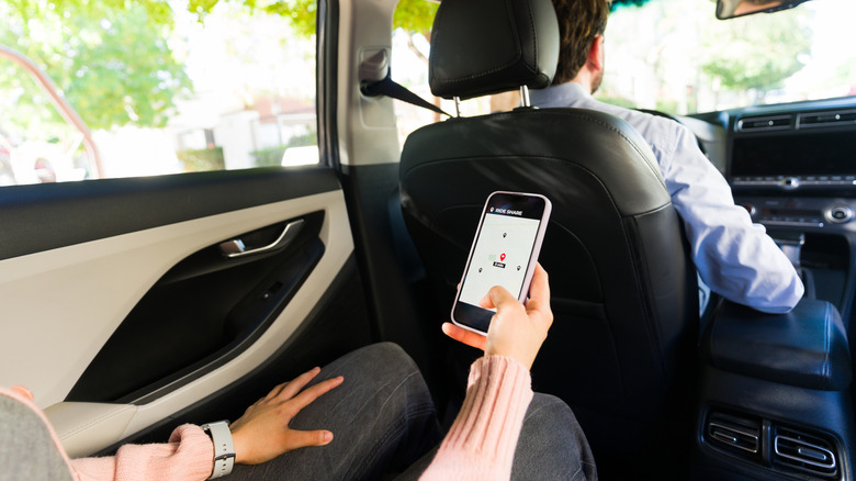 Person with cell phone in back seat of a car