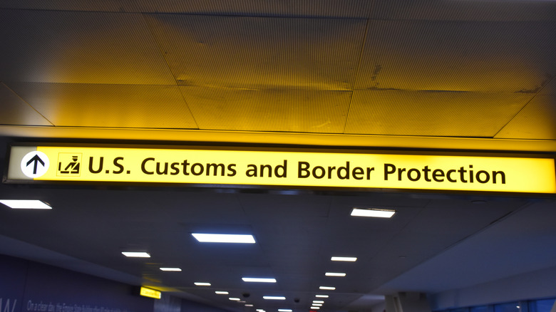 A sign showing the direction to the U.S. Customs and Border Protection office in an airport