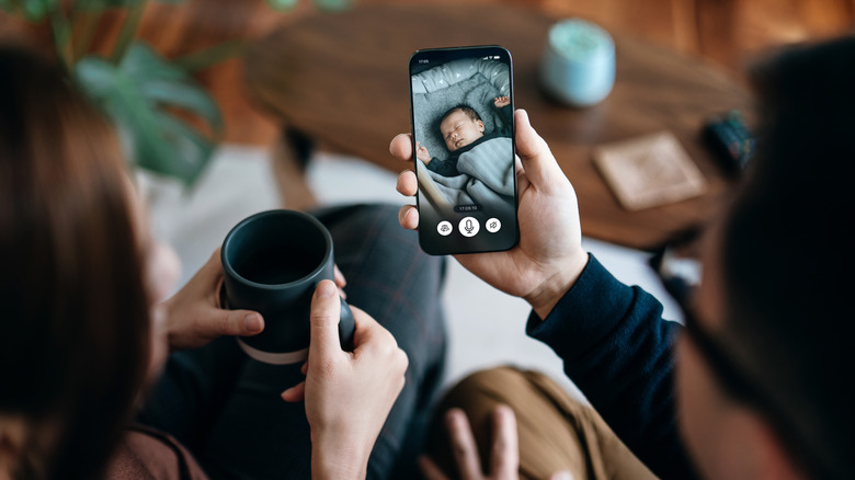 Parents monitoring their baby through a smartphone