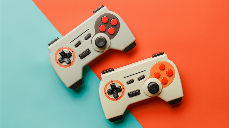 Top down view of two retro controllers with a two-tone background.