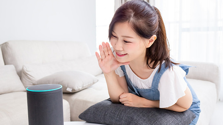 A lady smiling and talking to smart voice assistant