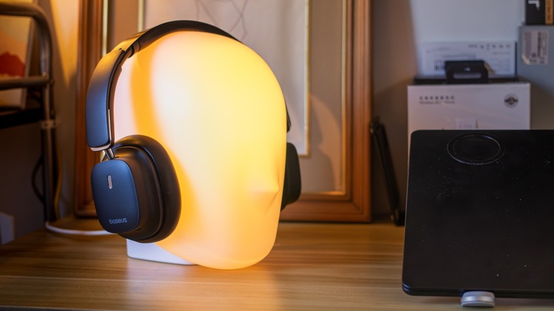 a pair of Baseus headphones on a head-shaped lamp