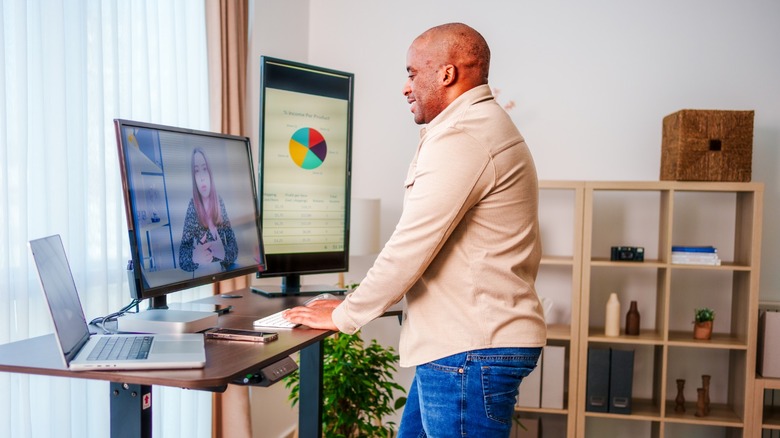 a person using a standing desk while on a virtual meeting