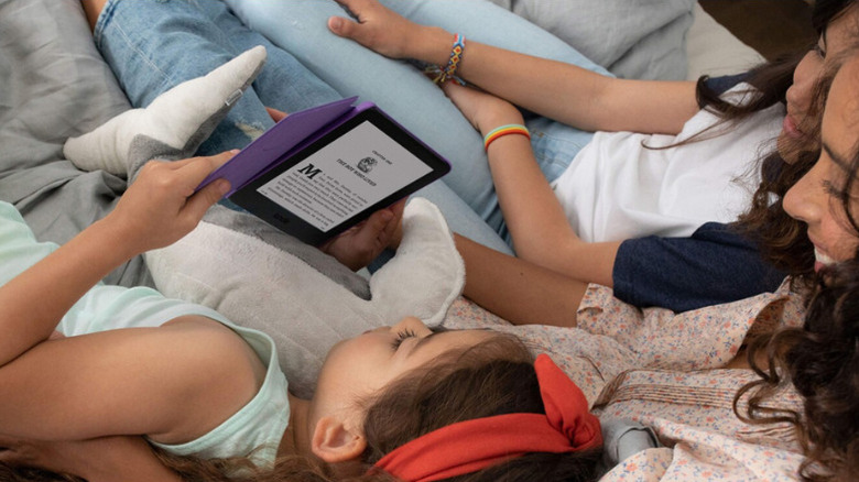 A kid reading on Kindle with her family